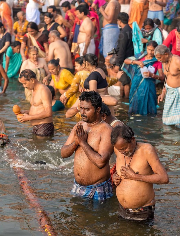 People perform ritual bath and puja prayers at ghats in the River Ganges