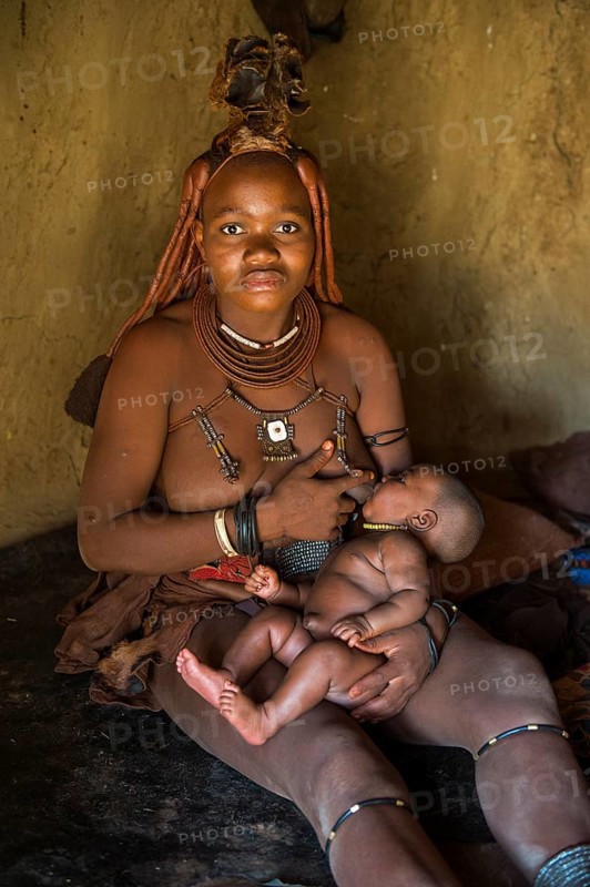 Himba woman breast feeding her baby