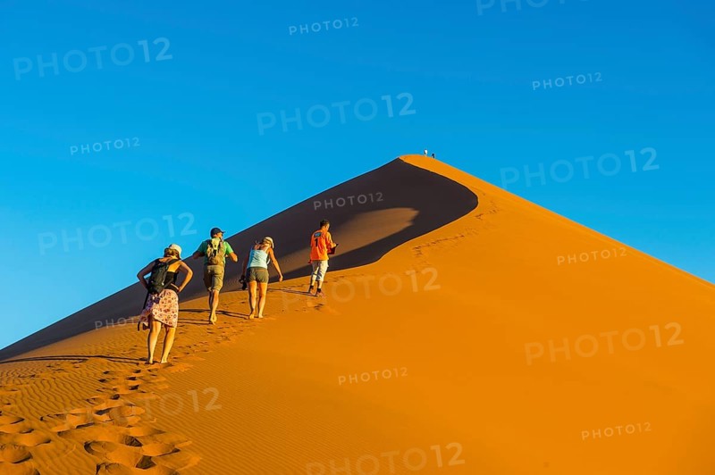 Tourist group walking up the giant sanddune Dune 45
