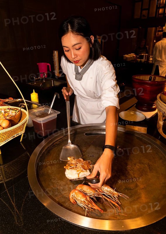 Thai cook preparing pad Thai and prawns