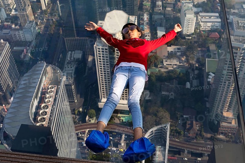 Little girl lies on the glass skywalk