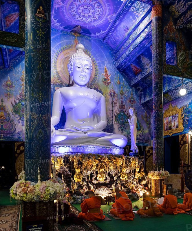 Monks in front of the blue Buddha statue of Wat Rong Seur Ten