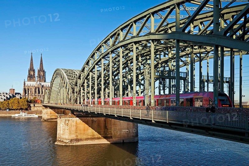 Cologne Cathedral with regional train on the Hohenzollern Bridge and the Rhine River