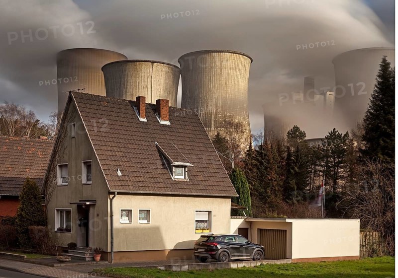 Residence in the Auenheim district in front of the steaming lignite-fired power plant Niederaussem