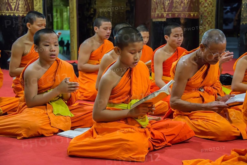 Buddhist monks praying in the temple Wat Xieng Thong