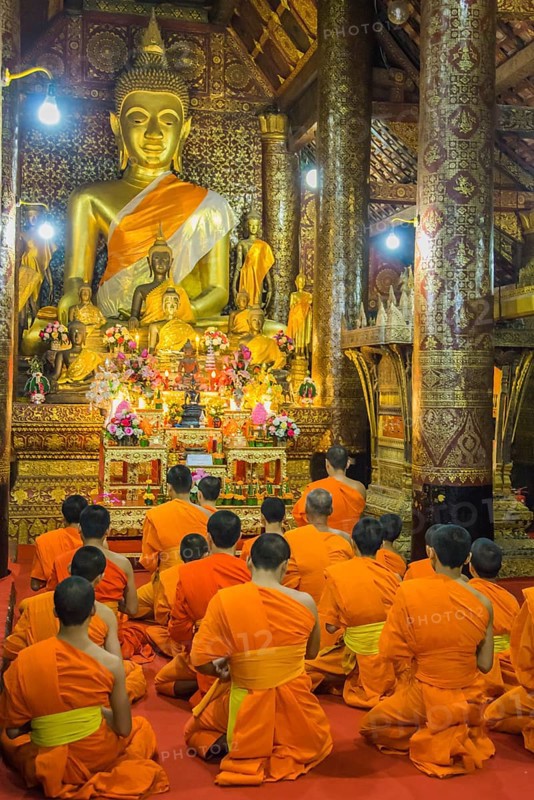 Buddhist monks praying in the temple Wat Xieng Thong