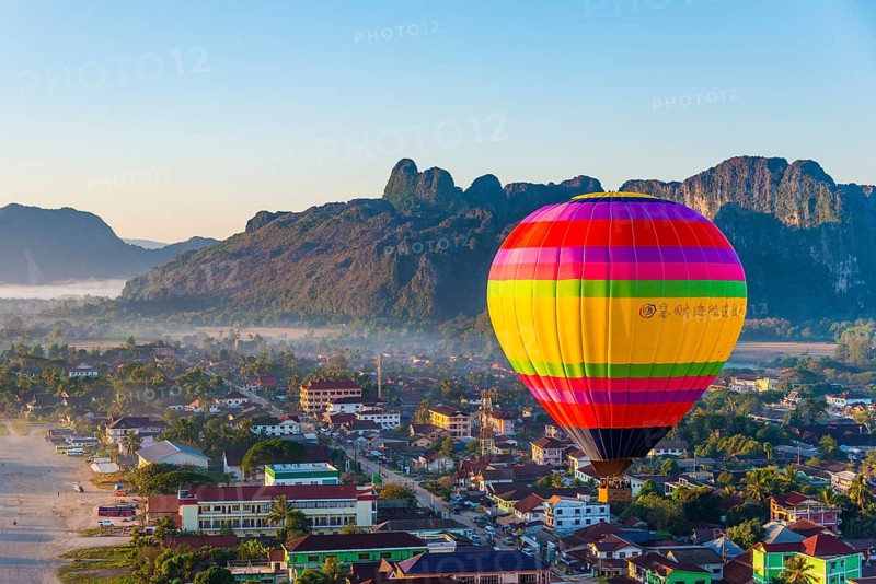 Colorful hot air balloon drifts over the city