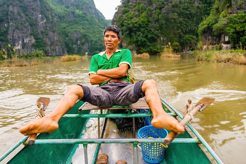 Local man rowing with his feet on the Ngo Dong River