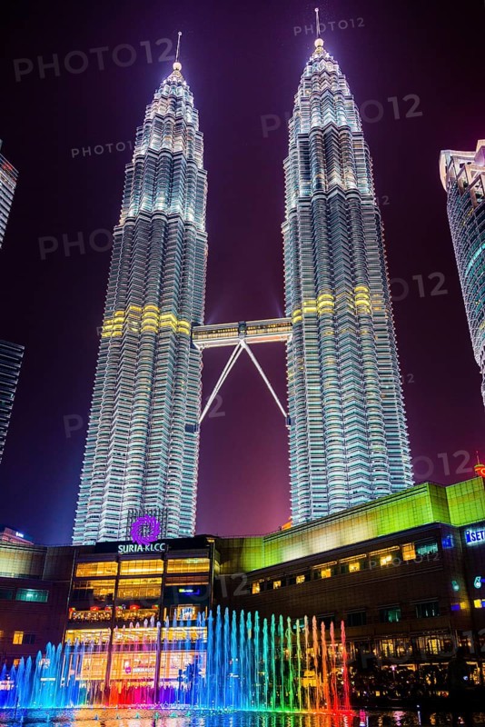 Lighted Petronas Towers with colored fountain at night