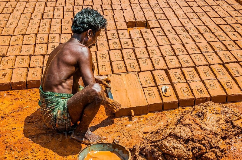 Indian man making clay bricks