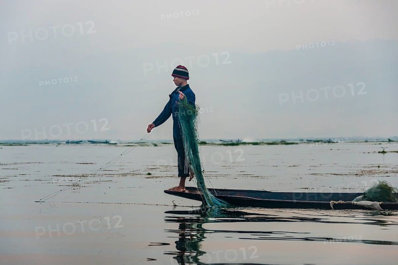 Local fisherman leg rower with wooden boat