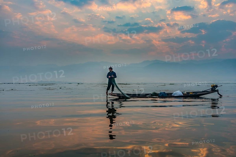 Local Intha fisherman rowing boat with one leg