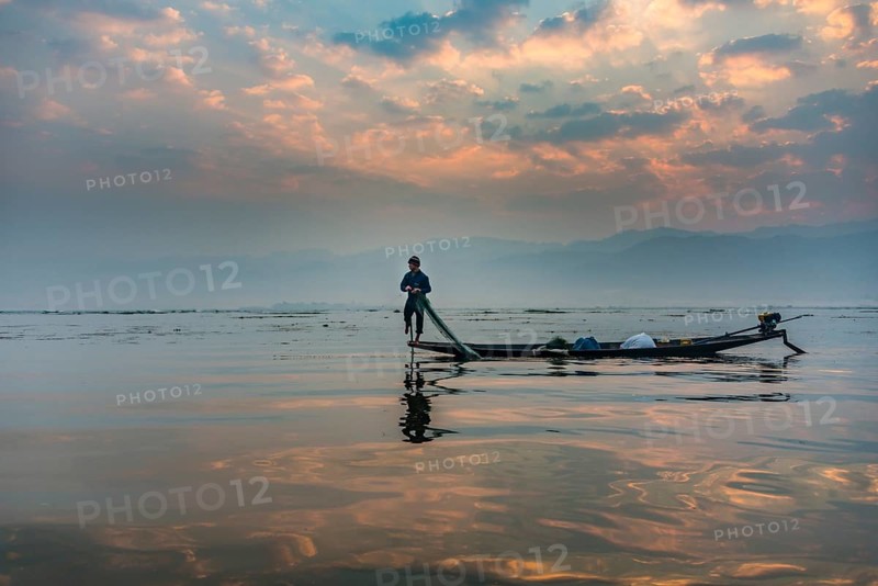 Local Intha fisherman rowing boat with one leg