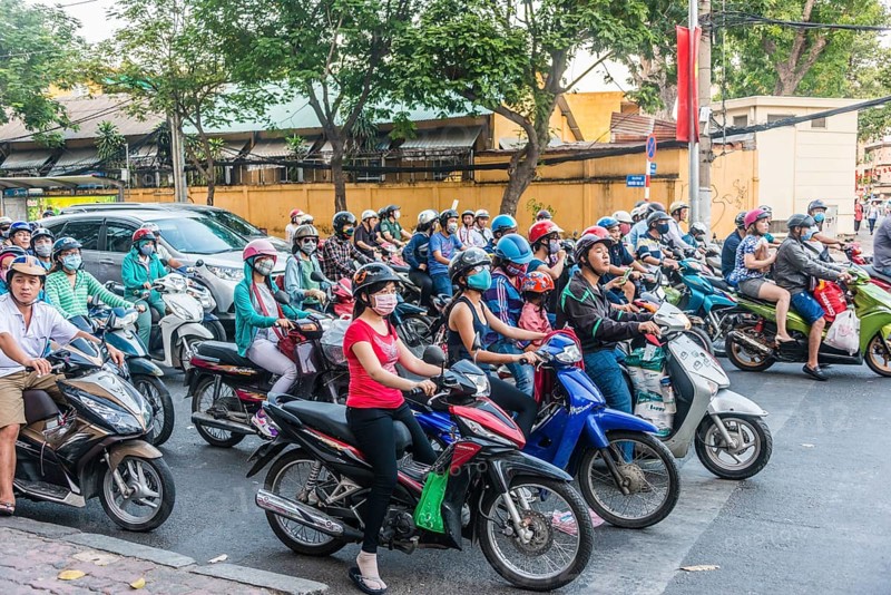 Crowd of scooter riders waiting at traffic light