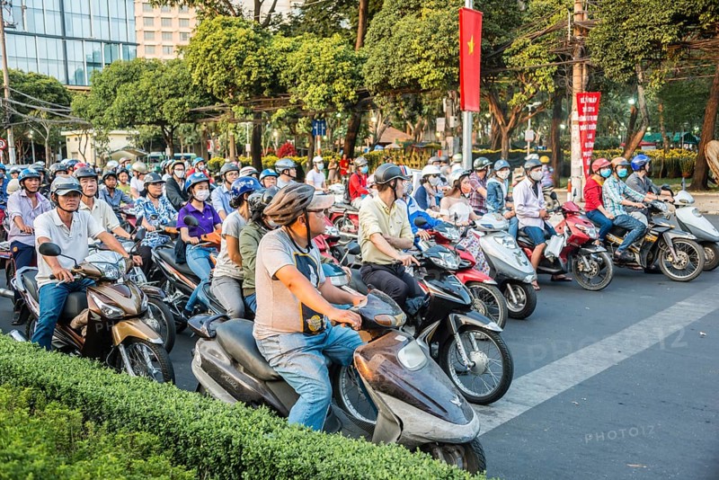 Crowd of scooter riders waiting at traffic light