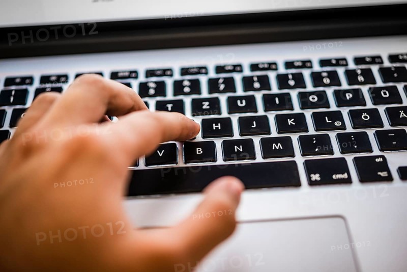 Hand typing on MacBook Pro keyboard