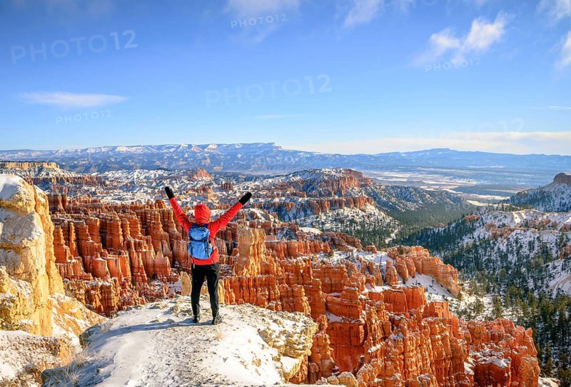 Young woman with outstretched arms and a view of the amphitheatre