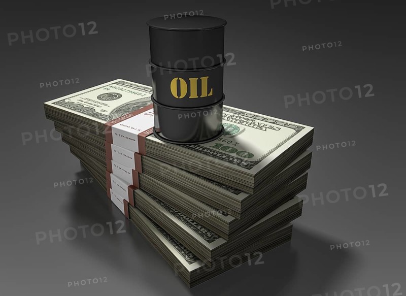 Oil barrel standing on stack of dollar bills