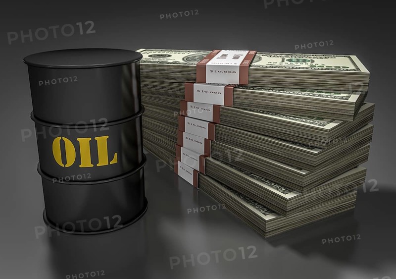 Oil barrel in front of stack of dollar bills