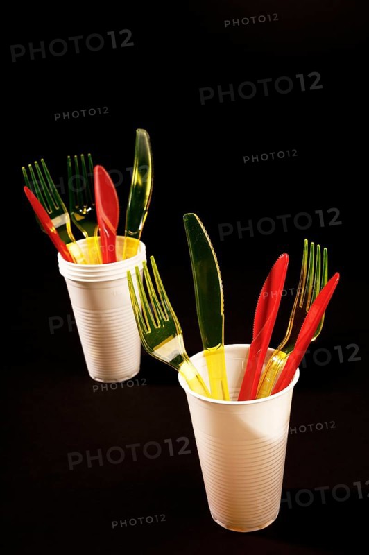 Red and yellow plastic cutlery in white plastic cups