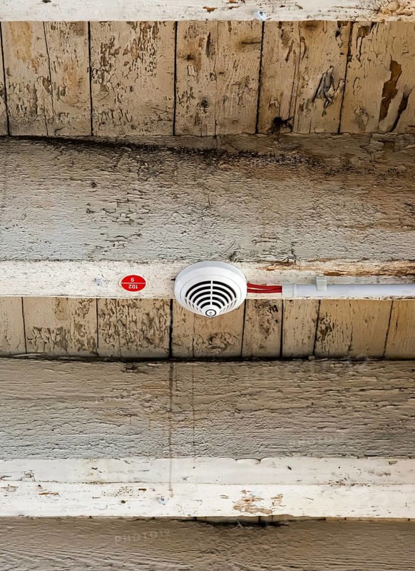 Smoke detector with electrical wiring on old wooden beam