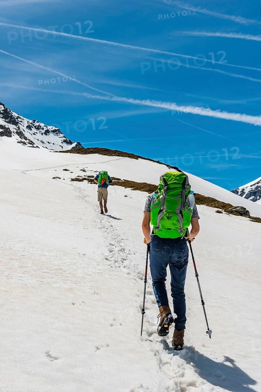 Two hikers walk over snowfield