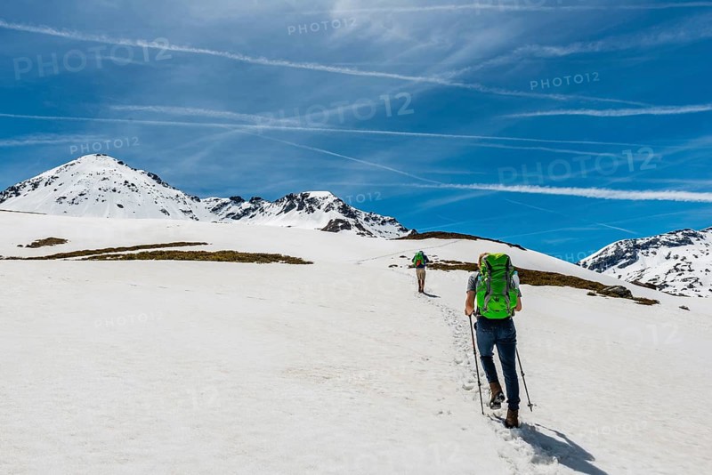 Two hikers walk over snowfield