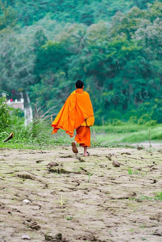 Buddhist monk running along banks of Mekong