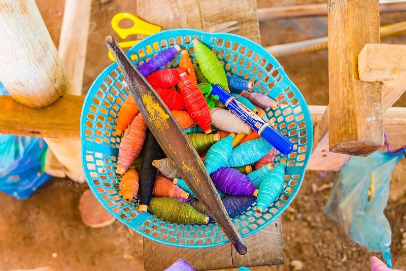 Basket with colorful yarn and needle for weaving
