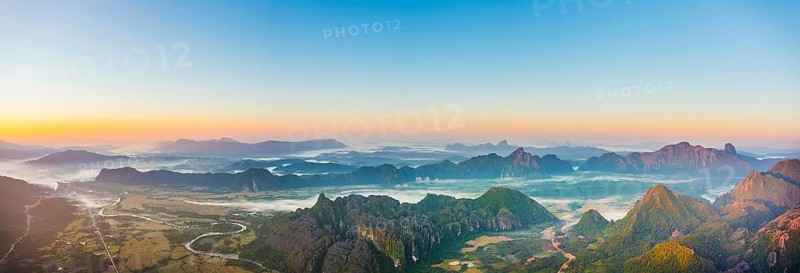 Panorama of karst mountains with mist at sunrise