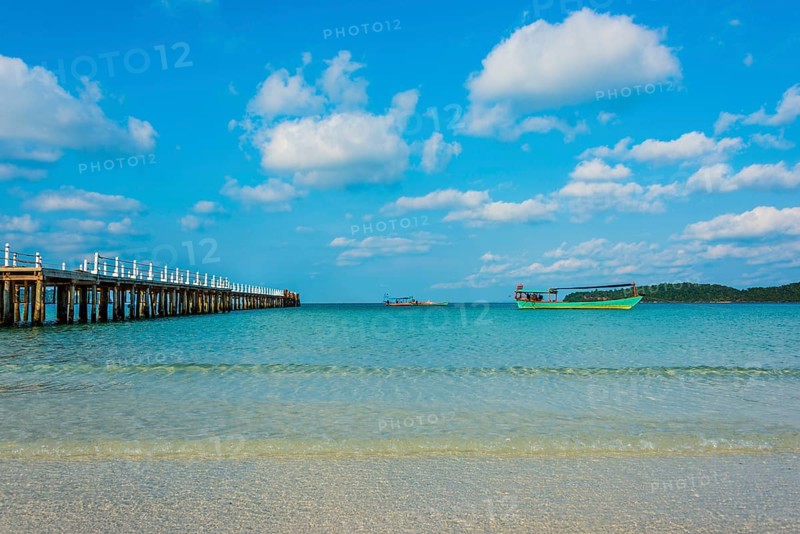 Pier on beach with boats in turquoise water at Saracen Bay on Koh Rong Sanloem island