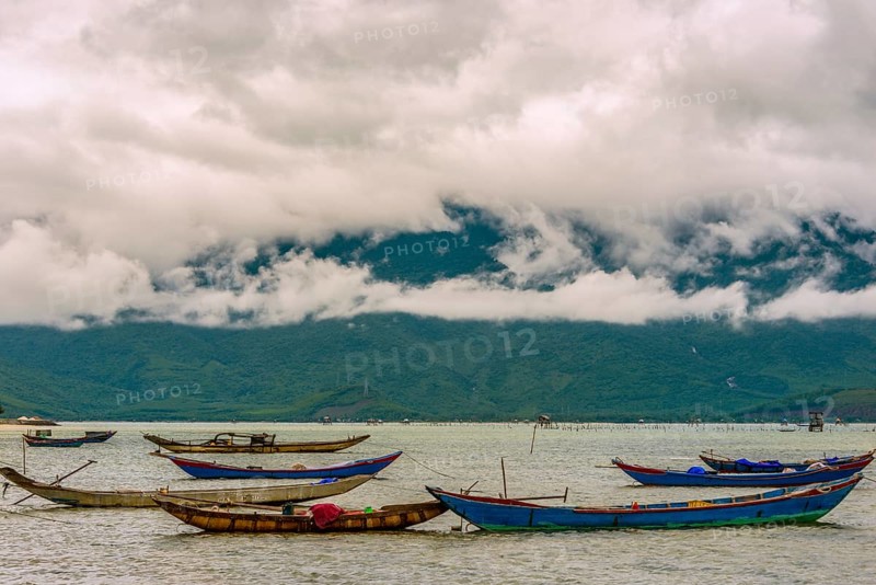Fishing boats on sea at coast with dramatic stormy clouds in Hue