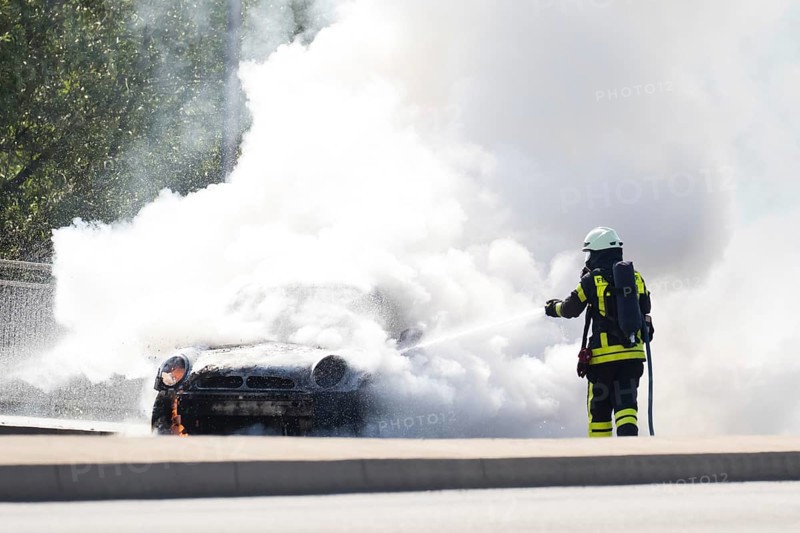 Firefighter extinguishes burning car
