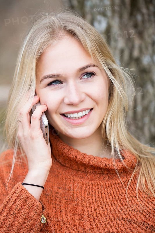 Blonde young woman phoning with a mobile