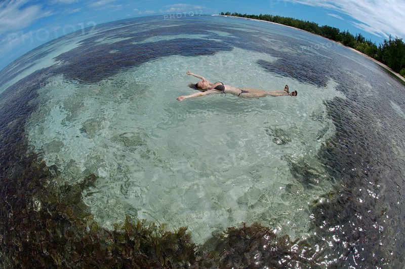 A young woman lying in the water on her back
