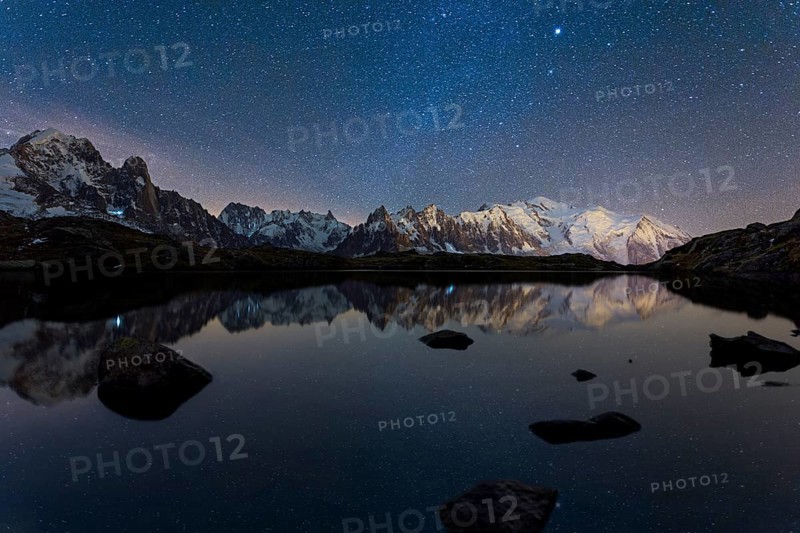 Starry sky with Milky Way and Mont Blanc massif reflected in the Lac des Chesery