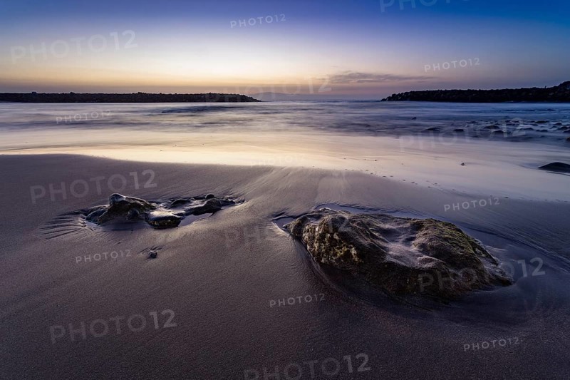 Beach with stones embedded in sand