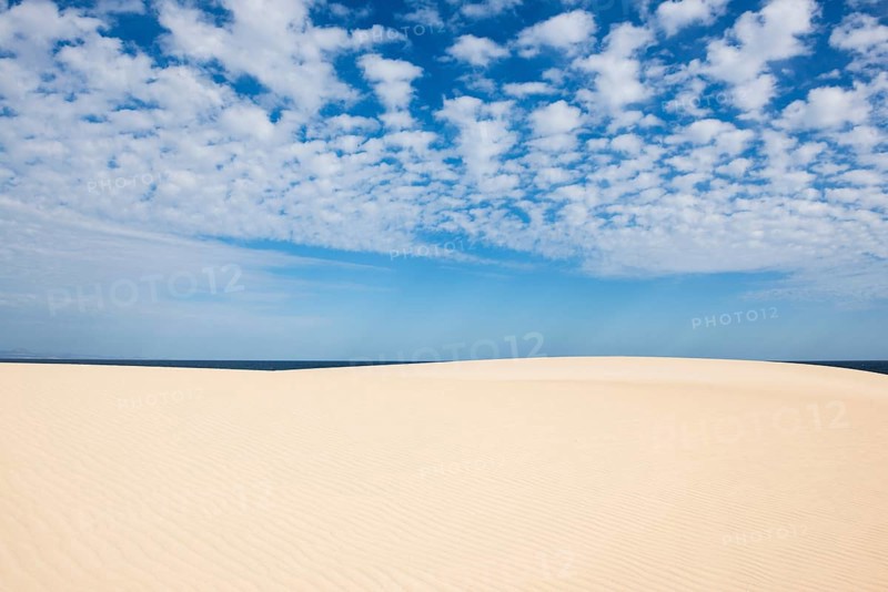 Dunes against blue sea