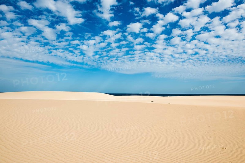 Dunes against blue sea