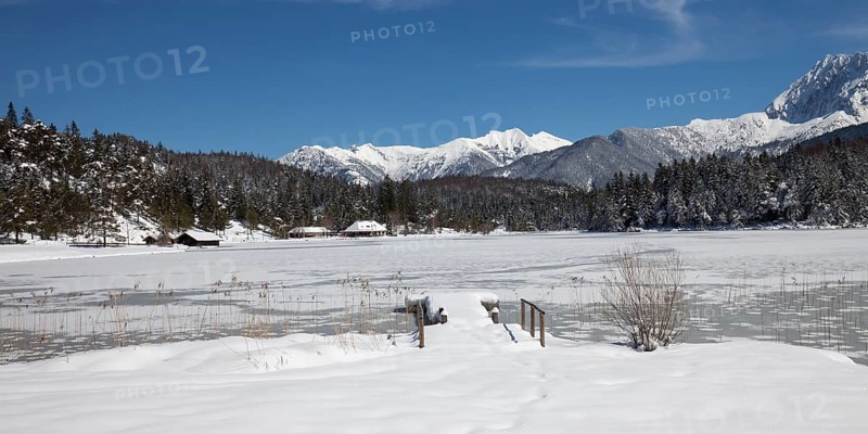Frozen lake Lautersee in front of Karwendel Mountains
