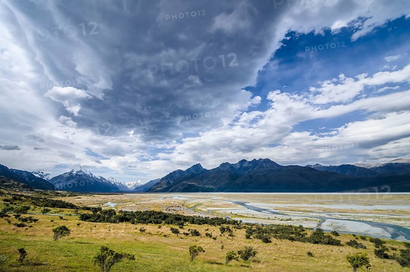 Grassland in front of the wide riverbed of the Tasman River