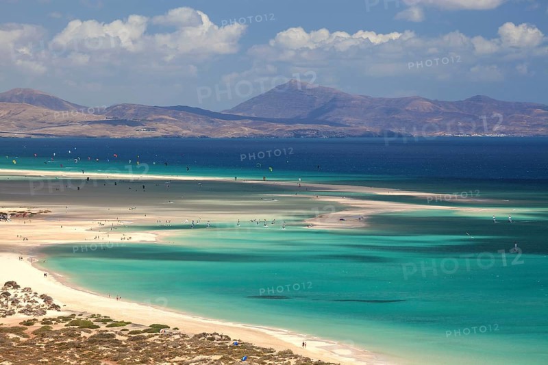 Beach and turquoise sea with windsurfers