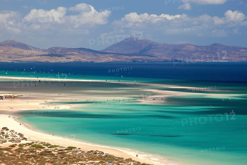 Beach and turquoise sea with windsurfers