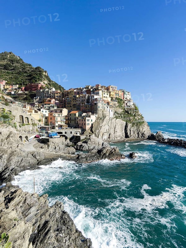 Rocky coast and view to the village of Manarola