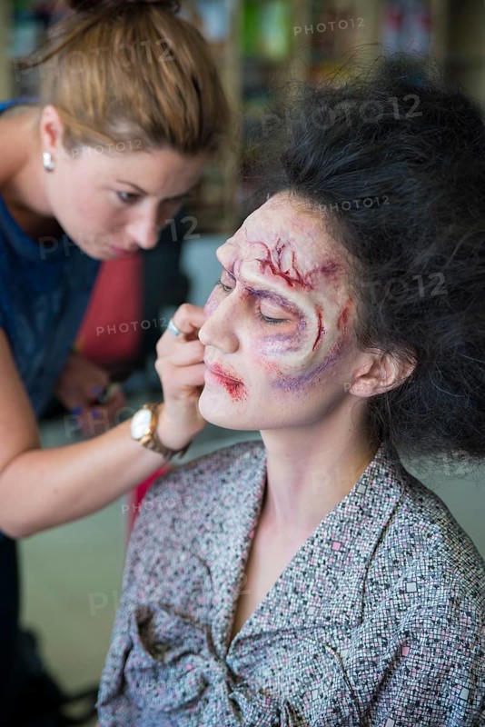 Actress being painted by makeup artist as a zombie for the zombie comedy Brain Freeze