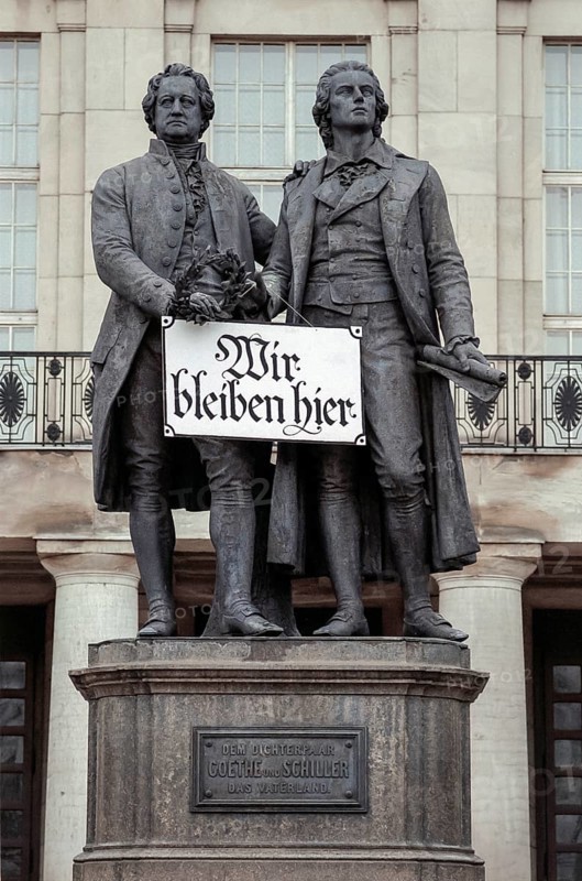 Goethe and Schiller monument with sign Wir bleiben hier or We stay here