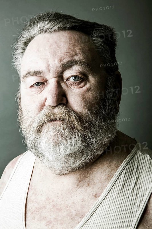 Obese senior with a full beard and in his undershirt