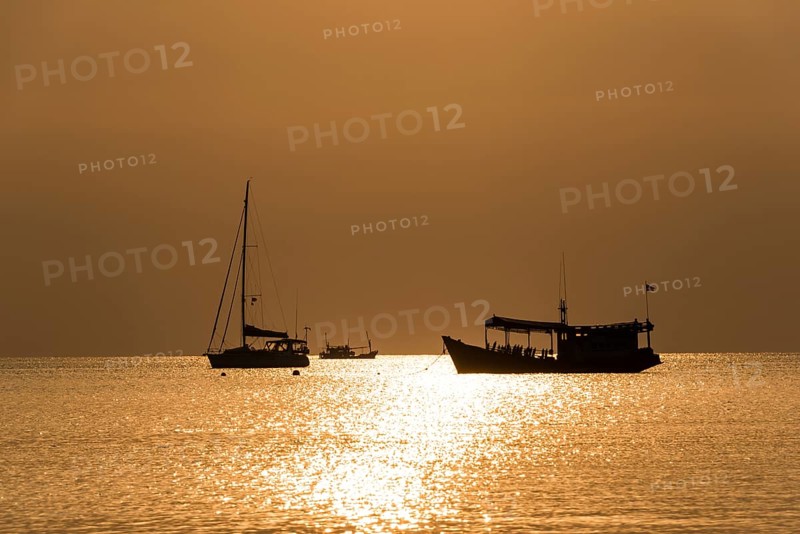 Two boats in sea at sunset