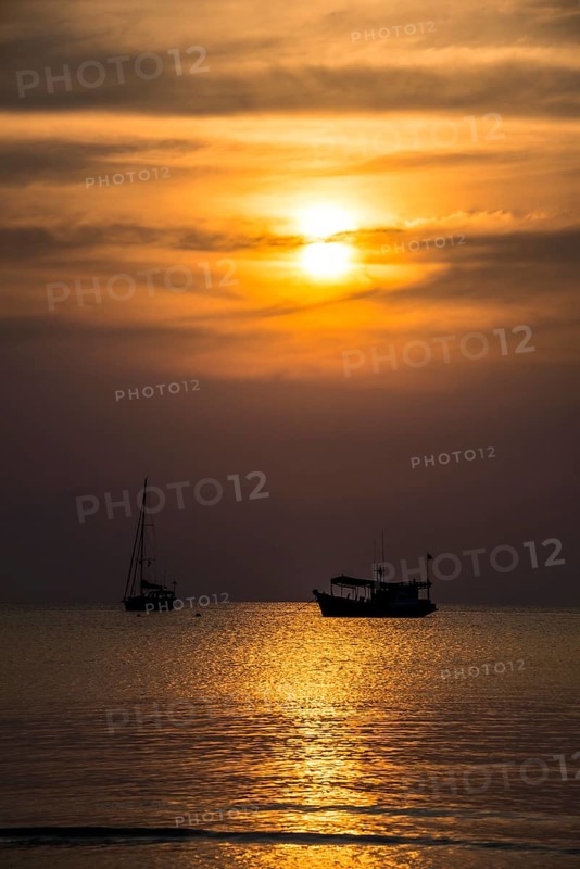 Two boats in sea at sunset
