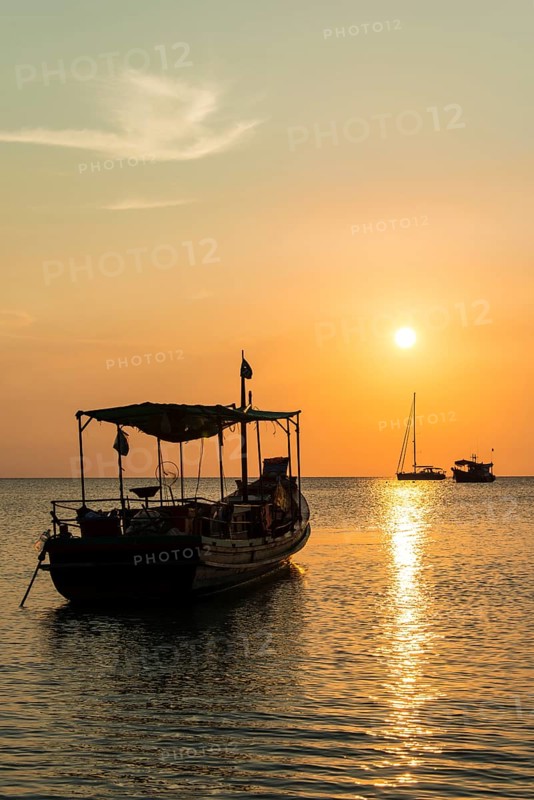 Fishing boat in sea at sunset